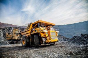 Large mining haul truck beside excavated rock in an open-pit mine
