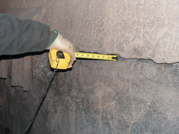 Engineer using infrared thermography to detect hot spots in a furnace refractory lining.