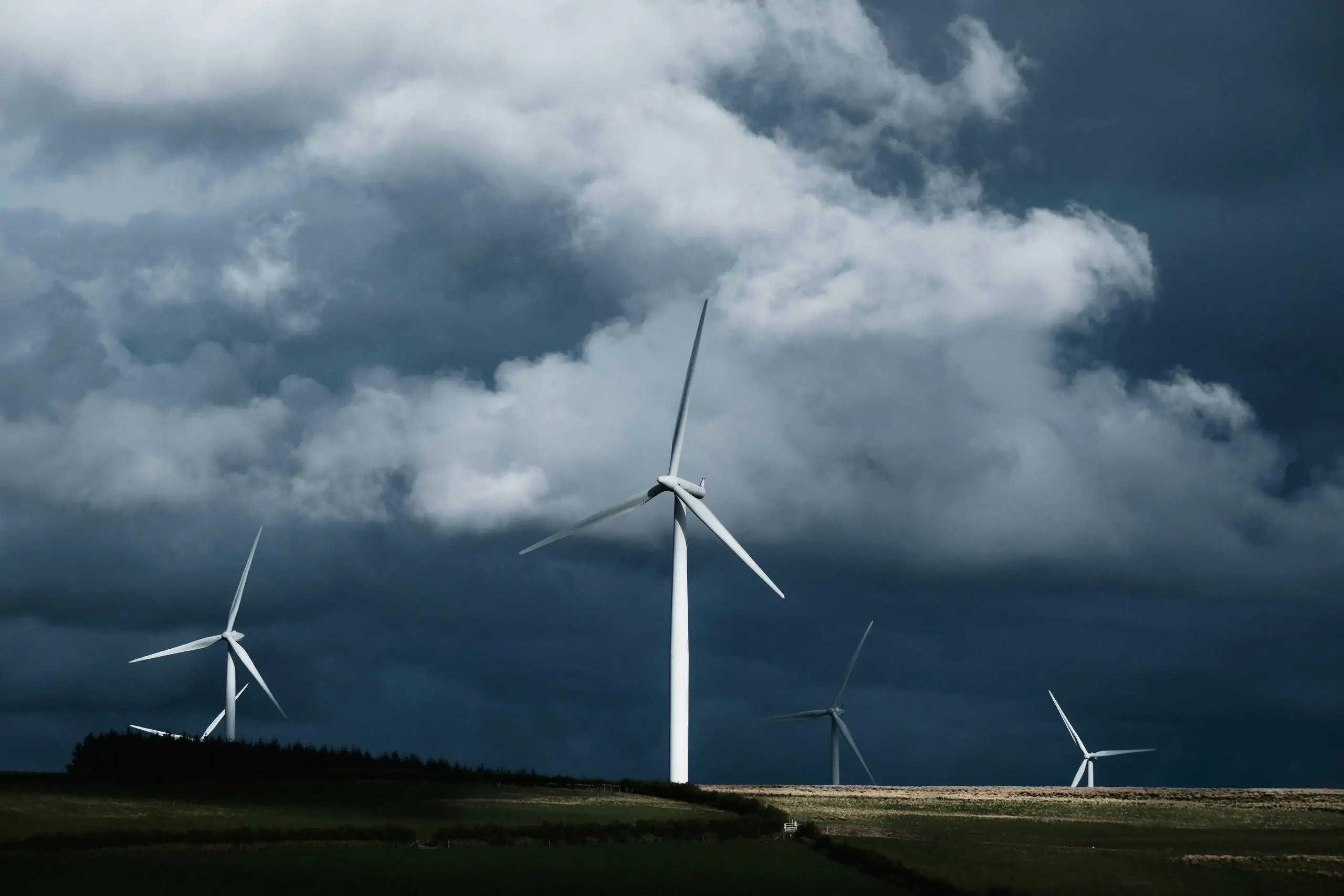 Wind turbines generating electricity beneath a cloudy sky